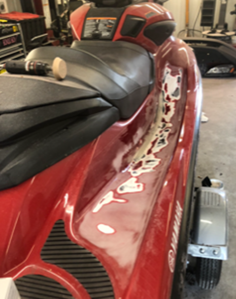 A red jet ski is parked in a garage