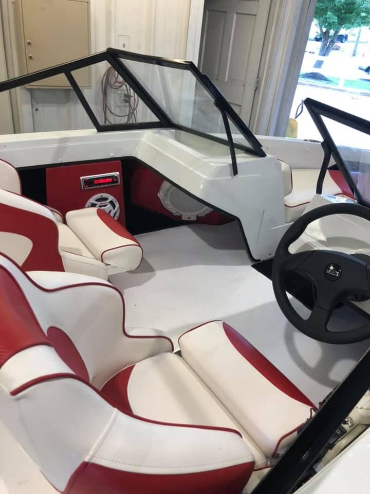 A boat with red and white seats and a steering wheel