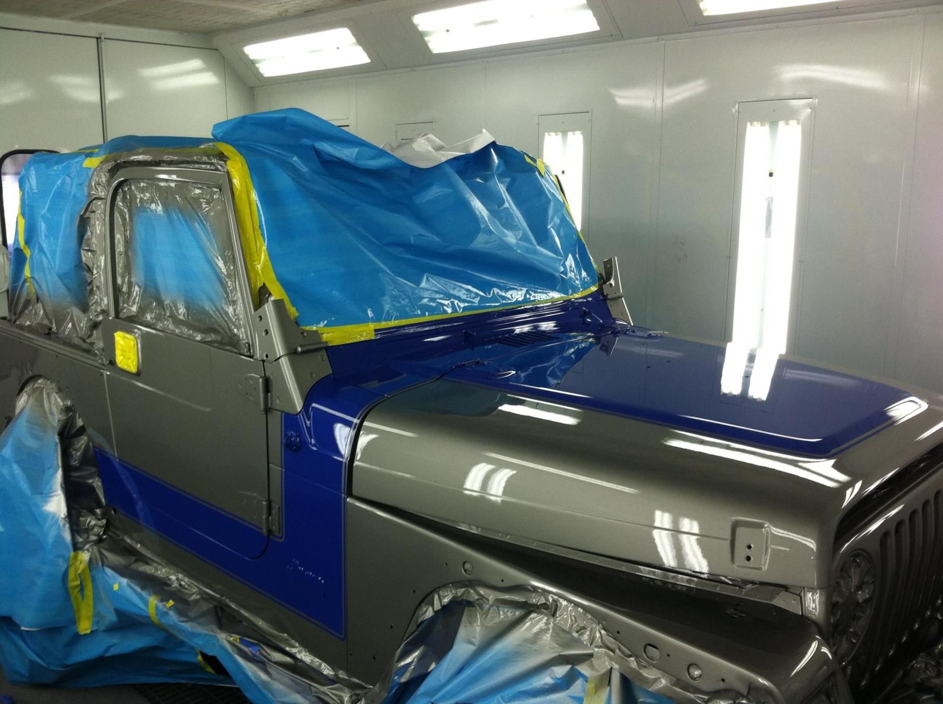 A jeep is being painted in a paint booth