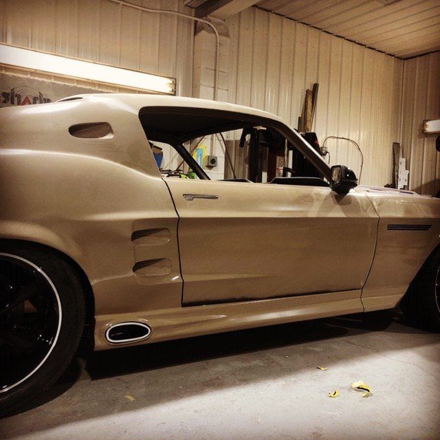 A car is parked in a garage with the word shark on the wall