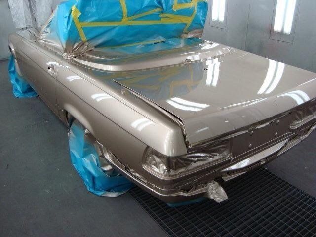 A car is being painted in a paint booth