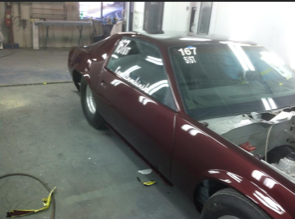 A red car with the number 167 on the windshield