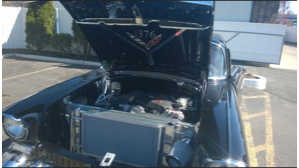 A black car with the hood up and a radiator