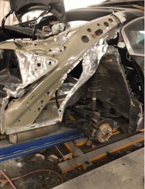 A car is being dismantled in a garage.