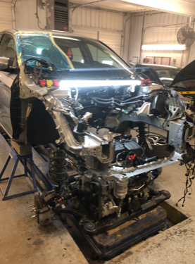 A car is being dismantled in a garage.