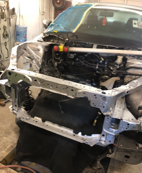 A car is being dismantled in a garage.