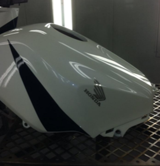 A white honda motorcycle is sitting on a metal shelf