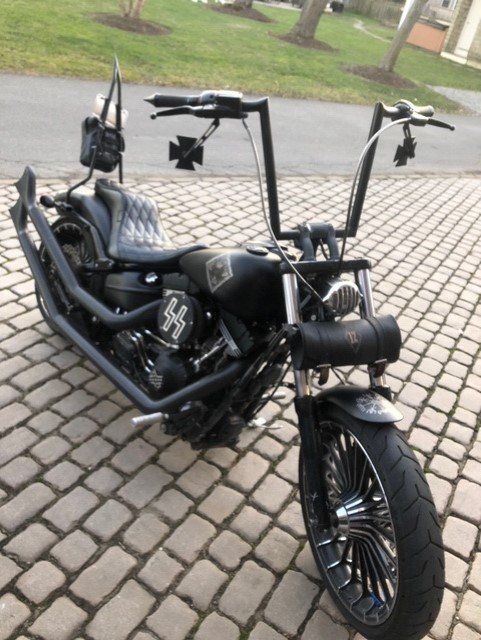 A black motorcycle is parked on a brick driveway