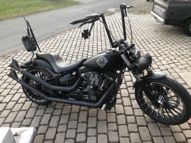 A black harley davidson motorcycle is parked on a brick driveway