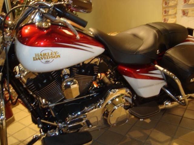 A red and white harley davidson motorcycle is parked on a tiled floor