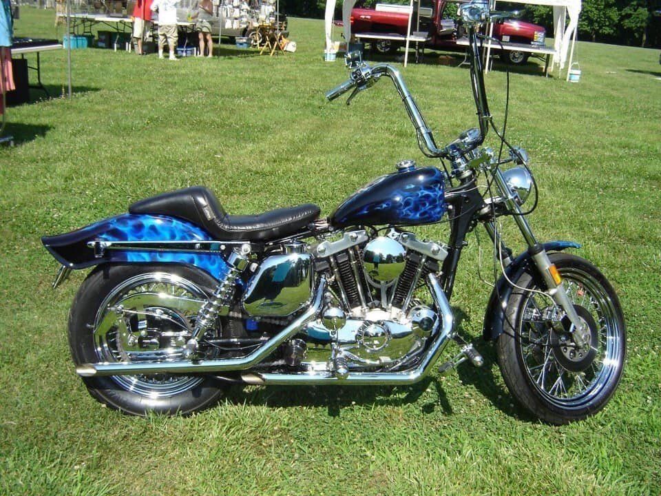 A blue and black motorcycle is parked in a grassy field
