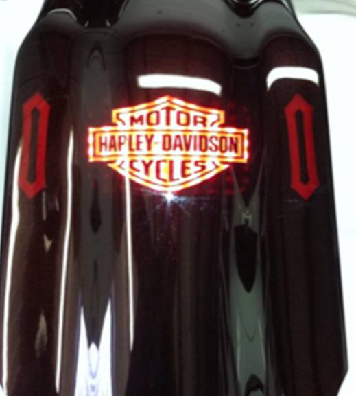 A harley davidson motorcycle is sitting on a white surface