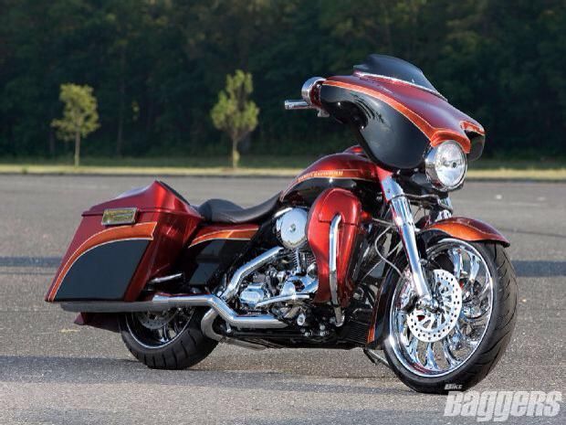 A red harley davidson motorcycle is parked in a parking lot