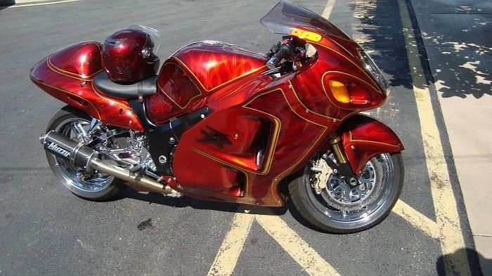 A red motorcycle is parked in a parking lot