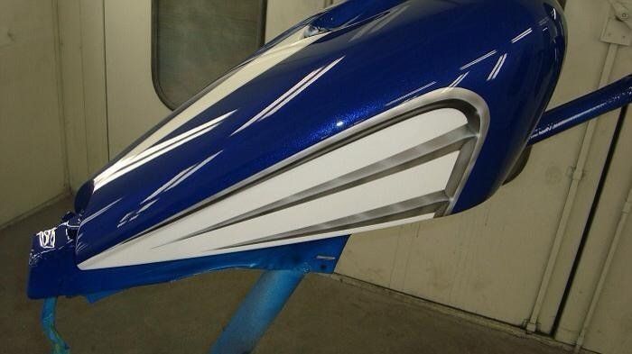 A blue and white motorcycle tank is sitting on a table.
