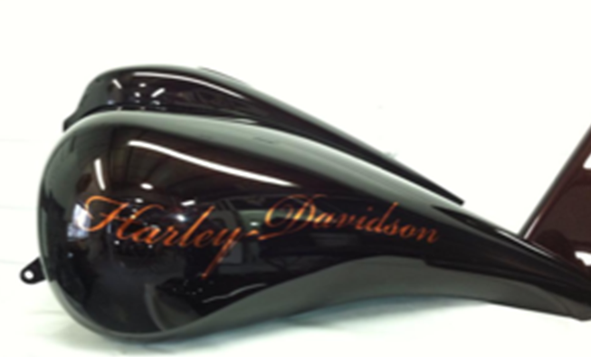 A harley davidson motorcycle tank is sitting on a white surface