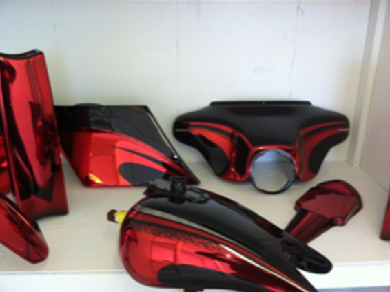 Red and black motorcycle parts on a white shelf