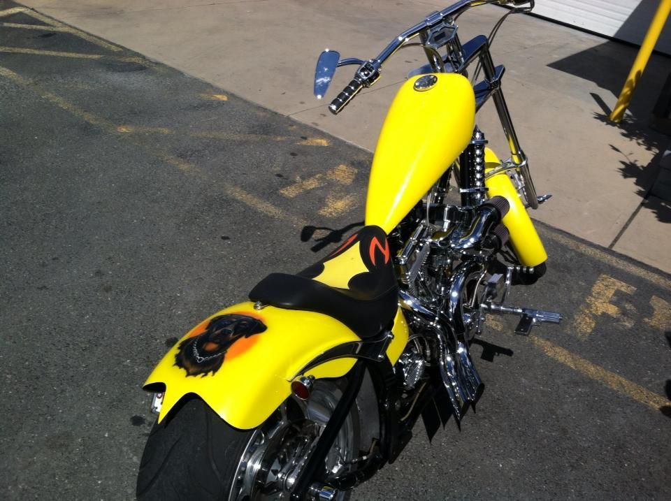 A yellow motorcycle with the letter n on the seat