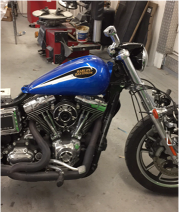 A blue harley davidson motorcycle is parked in a garage