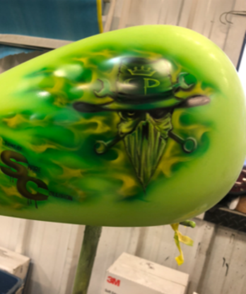 A green balloon with a picture of a skull on it