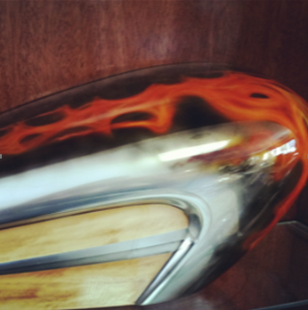 A close up of a metal object with orange flames painted on it