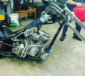 A man is standing next to a chopper motorcycle