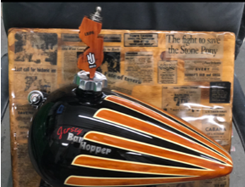 A black and orange motorcycle tank with the word hopper on it