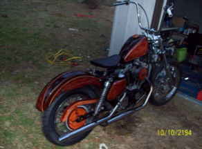 A motorcycle is parked in front of a garage on 10/10/194