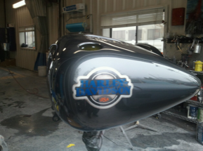 A harley davidson motorcycle is being painted in a garage