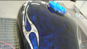 A black tank with blue flames painted on it