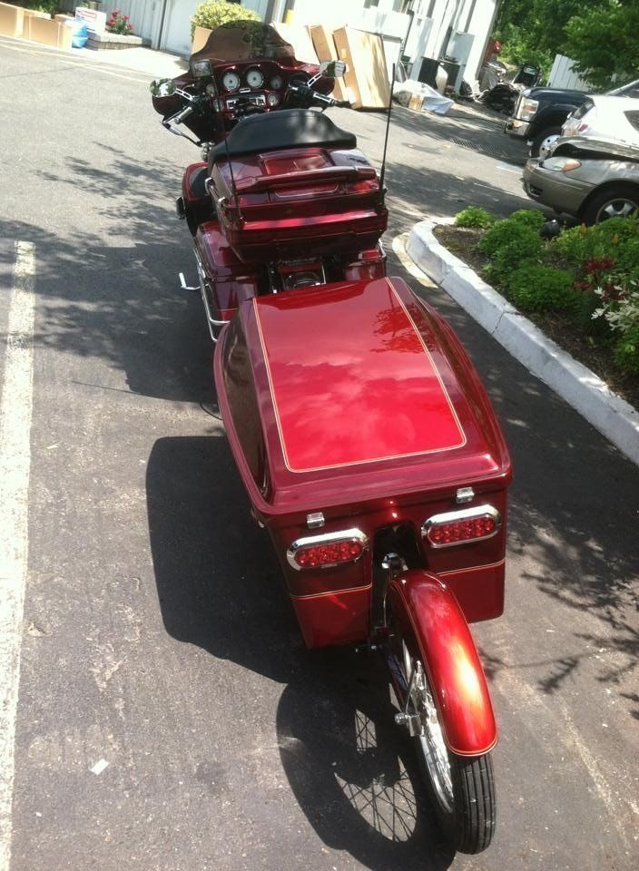 A red motorcycle is parked on the side of the road