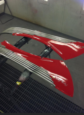 A pair of red fenders are sitting on a metal grate