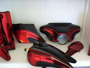 Red and black motorcycle parts on a white shelf