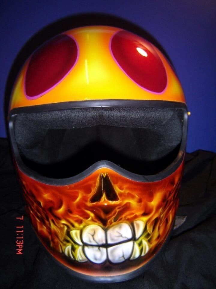 A motorcycle helmet with a skull and flames painted on it