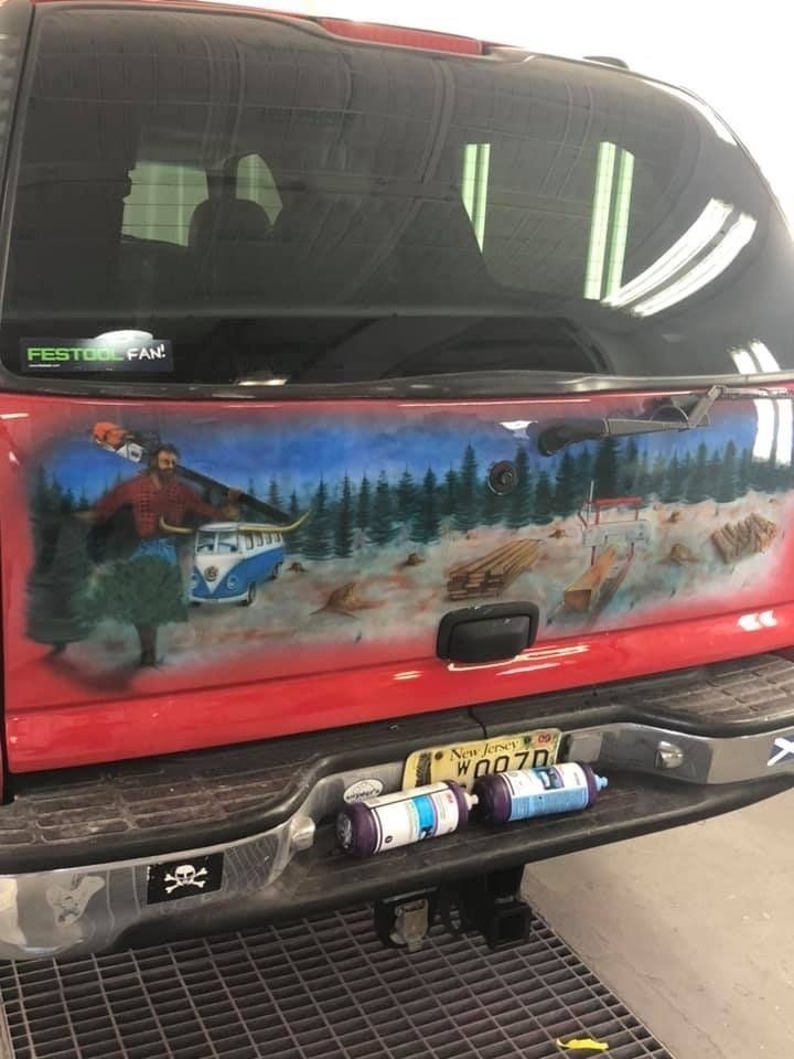 A red truck with a painting on the back of it