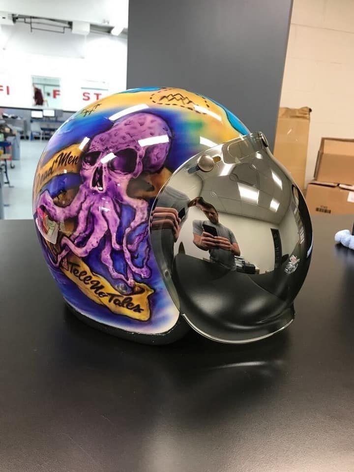 A motorcycle helmet with a purple octopus on it