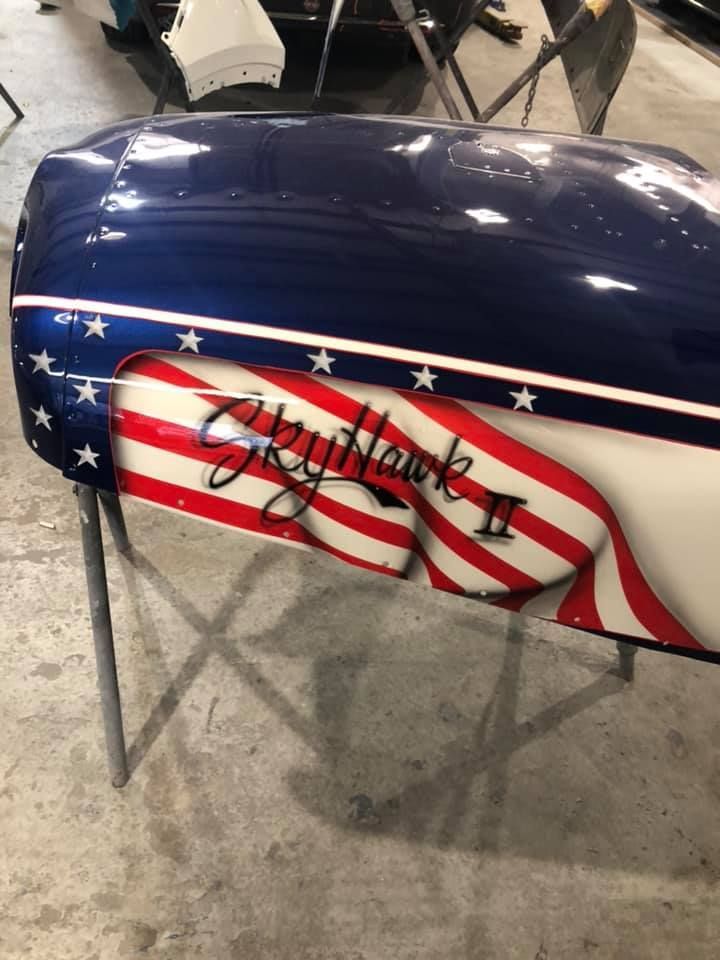 A blue and white motorcycle with the word skyhawk painted on it