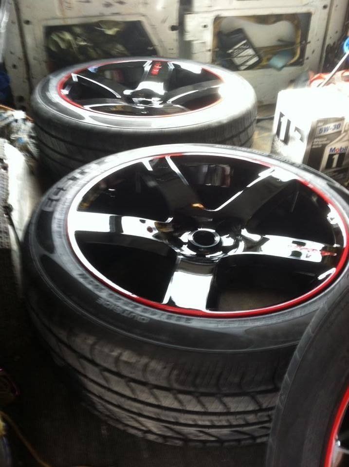 A stack of black and red wheels and tires