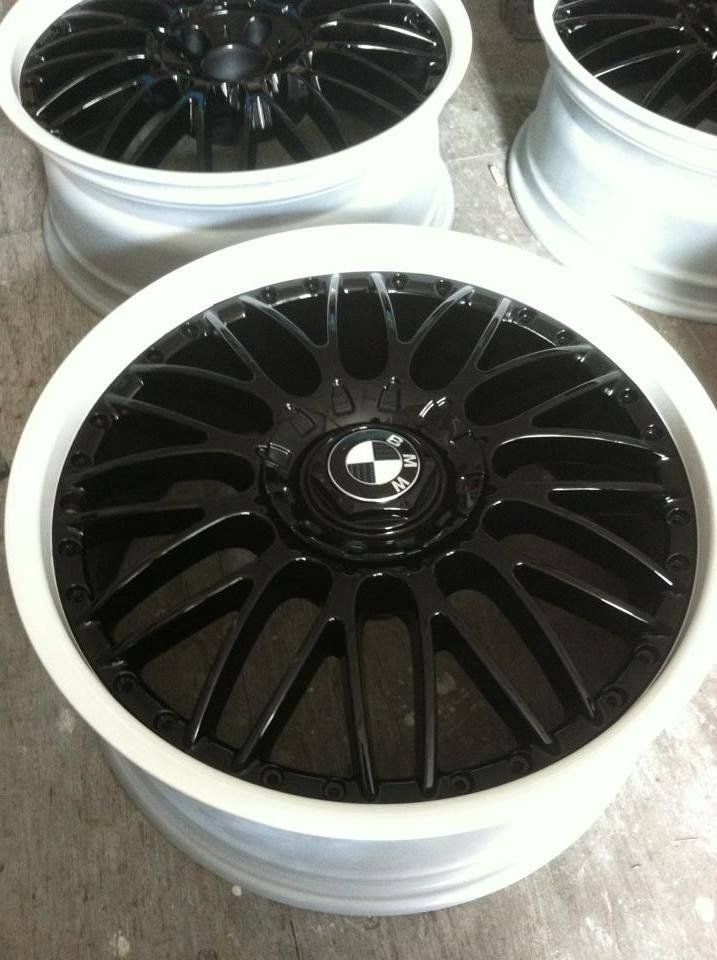 A pair of black bmw wheels with white rims