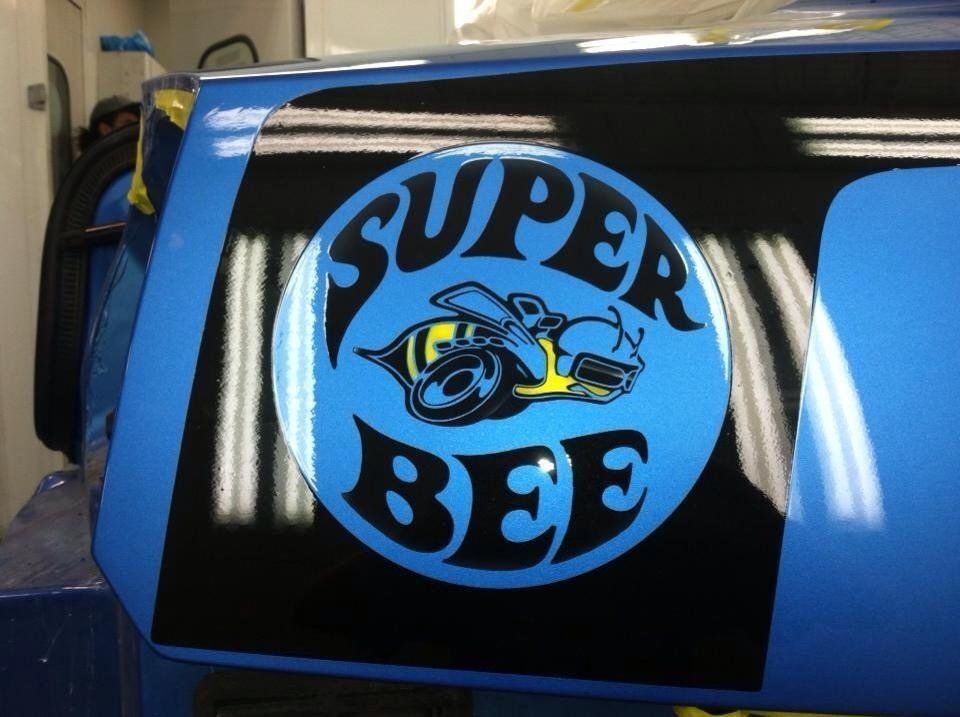 A blue car with a super bee logo on it