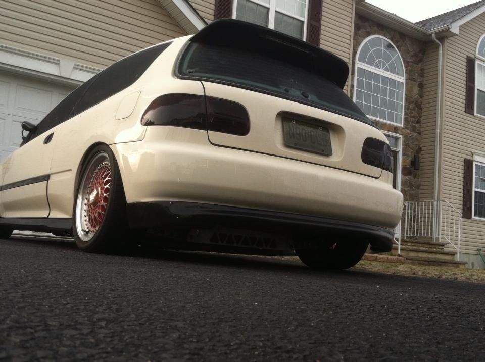 A white car is parked in front of a house