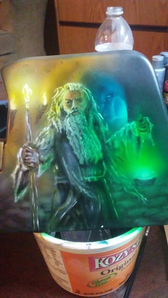 A painting of a wizard is sitting on top of a bowl of yogurt.