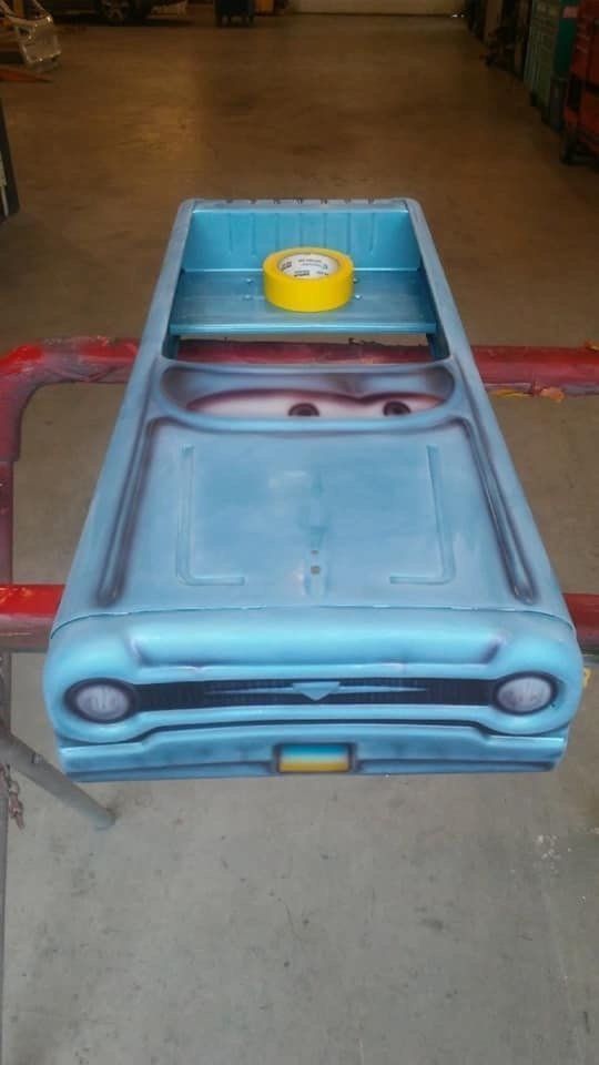 A blue toy truck with a yellow tape on top of it is sitting on a table.