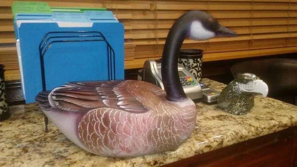A statue of a goose is sitting on a counter.