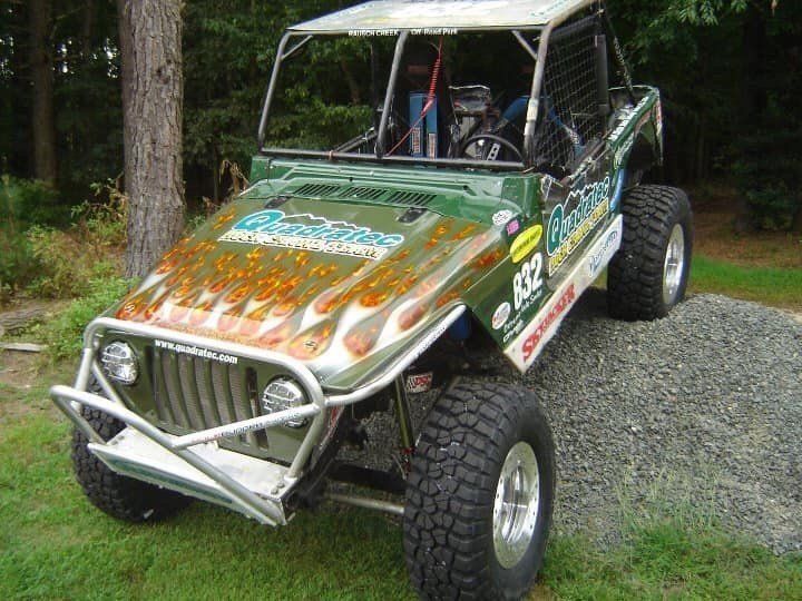 A green jeep with flames painted on the hood
