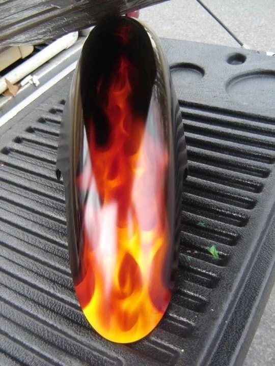 A motorcycle fender with flames painted on it