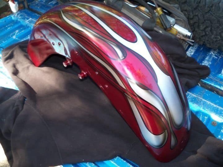 A red motorcycle fender with flames painted on it