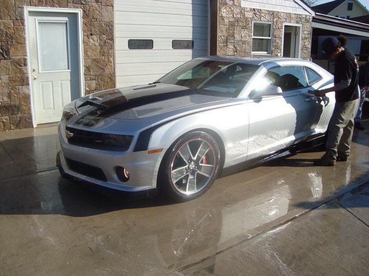 A silver car is parked in front of a garage door