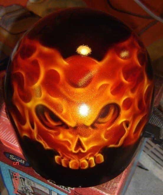 A helmet with a skull and flames painted on it