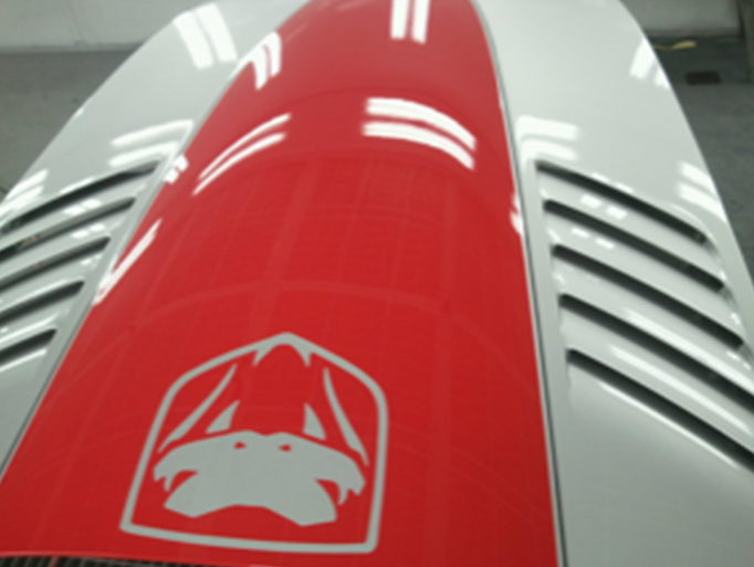 A close up of a red and white car hood